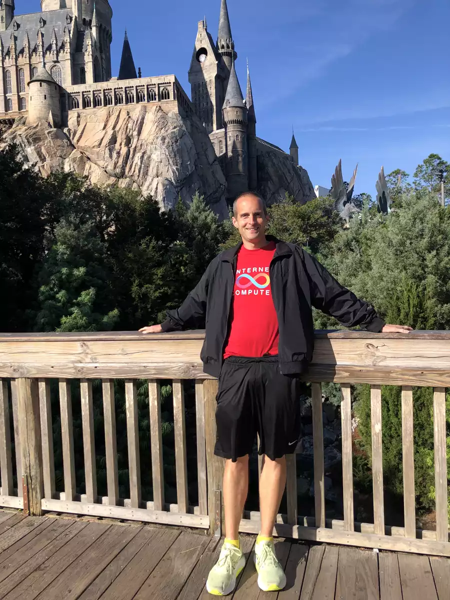 Jerry on a deck in front of a castle on a sunny day