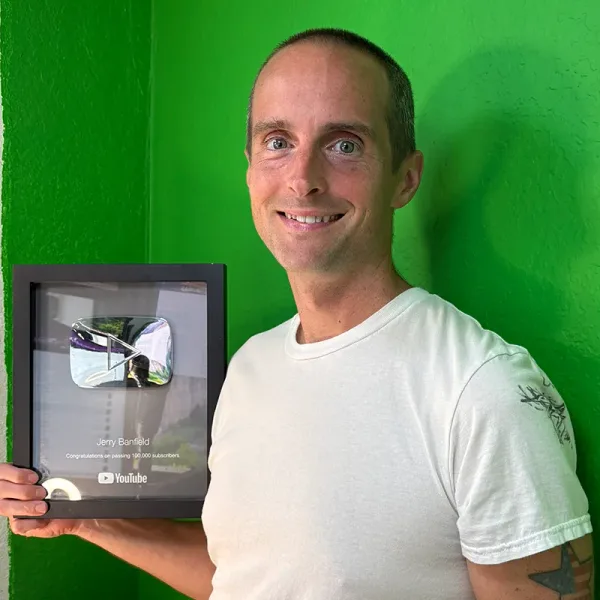 Jerry Banfield holding his YouTube silver play button award